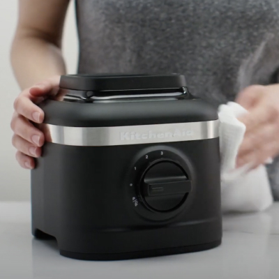 Person cleaning black KitchenAid® blender base
